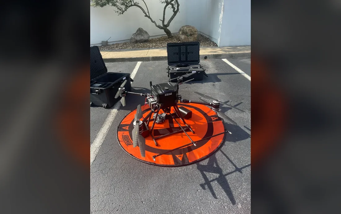 Drone professionnel H2O Drone posé sur une aire de décollage avec ses équipements et caisses de transport